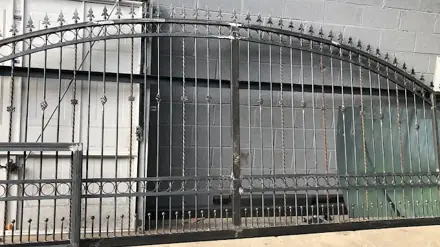 Long arched metal gate with vertical bars